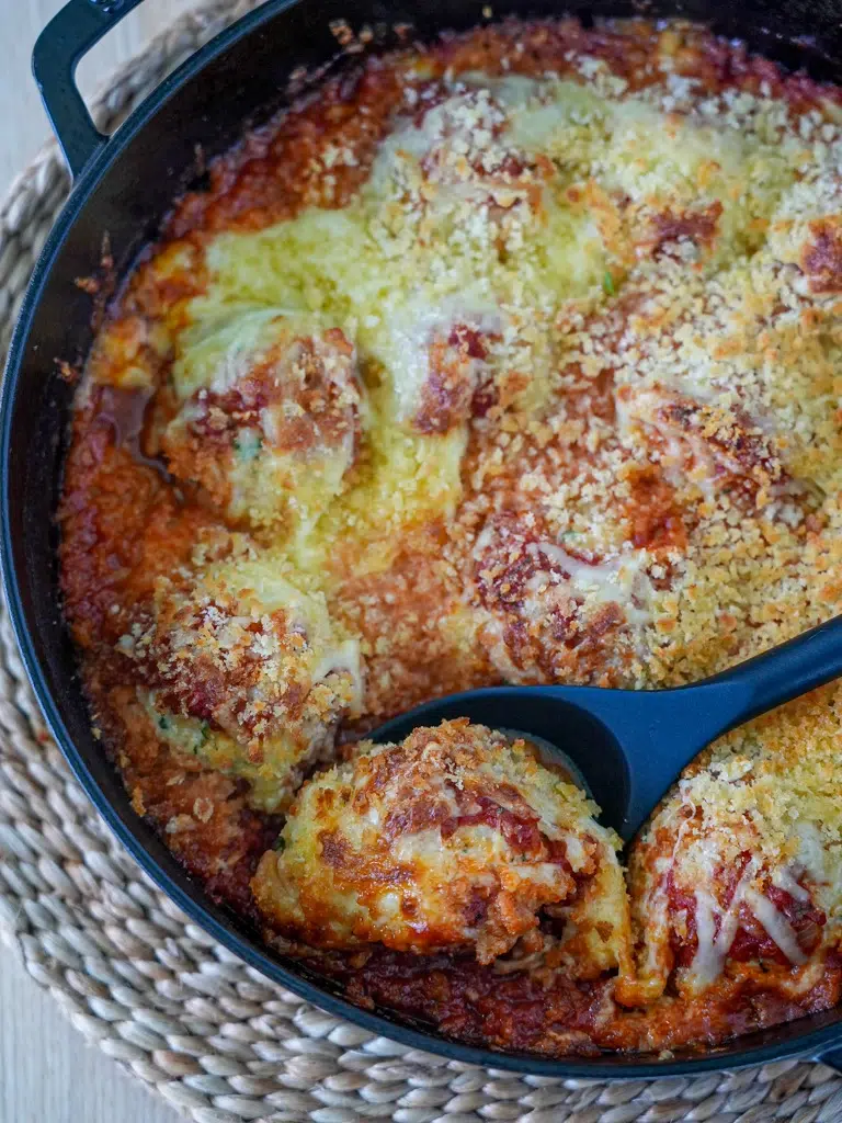 Close-up of a spoon scooping Chicken Meatball Parmigiana