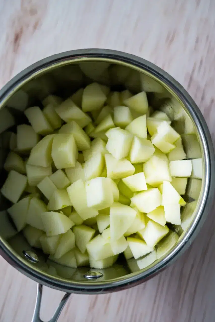 Cut up green apples in pot