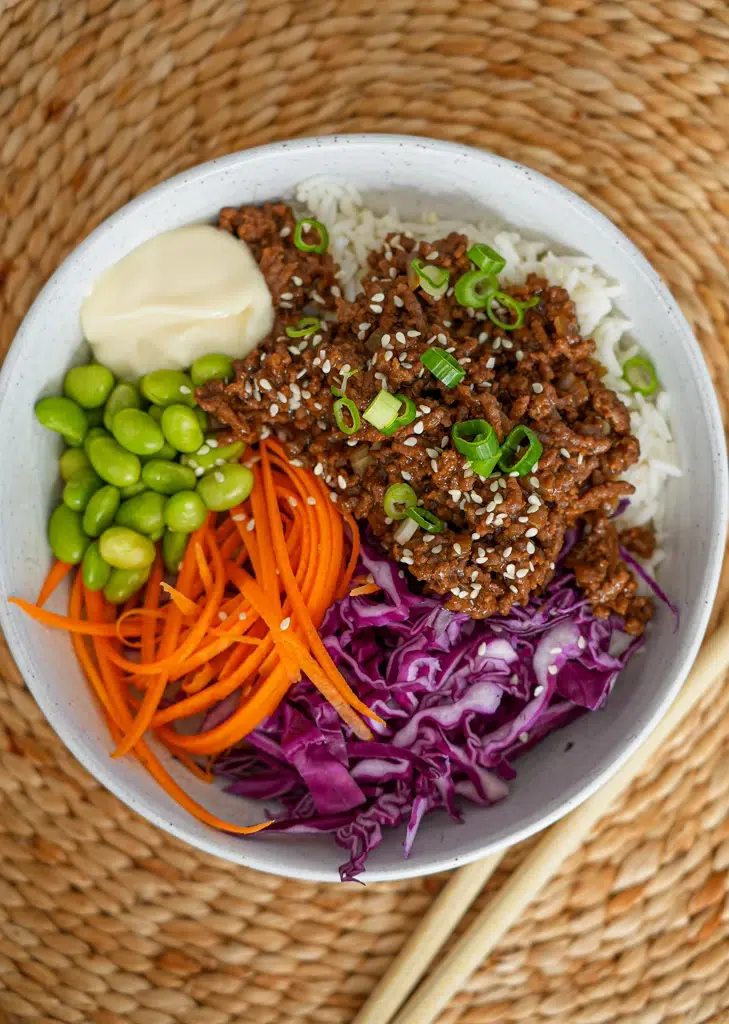 beef and vegetables in a glossy teriyaki sauce, garnished with sesame seeds and green onions.