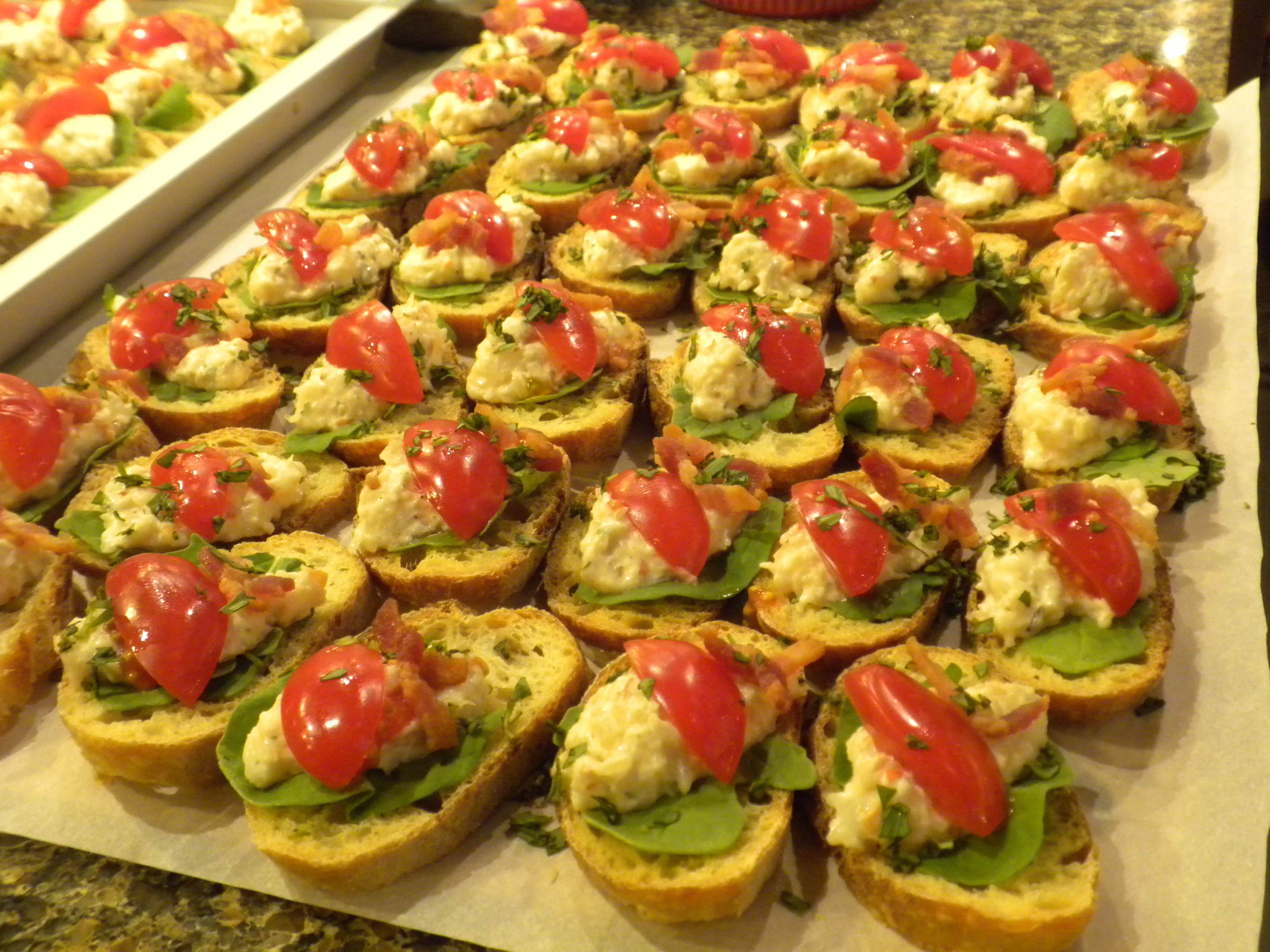 tarragon shrimp salad with arugula, tomatoes, crumbled bacon on a toasted crostini