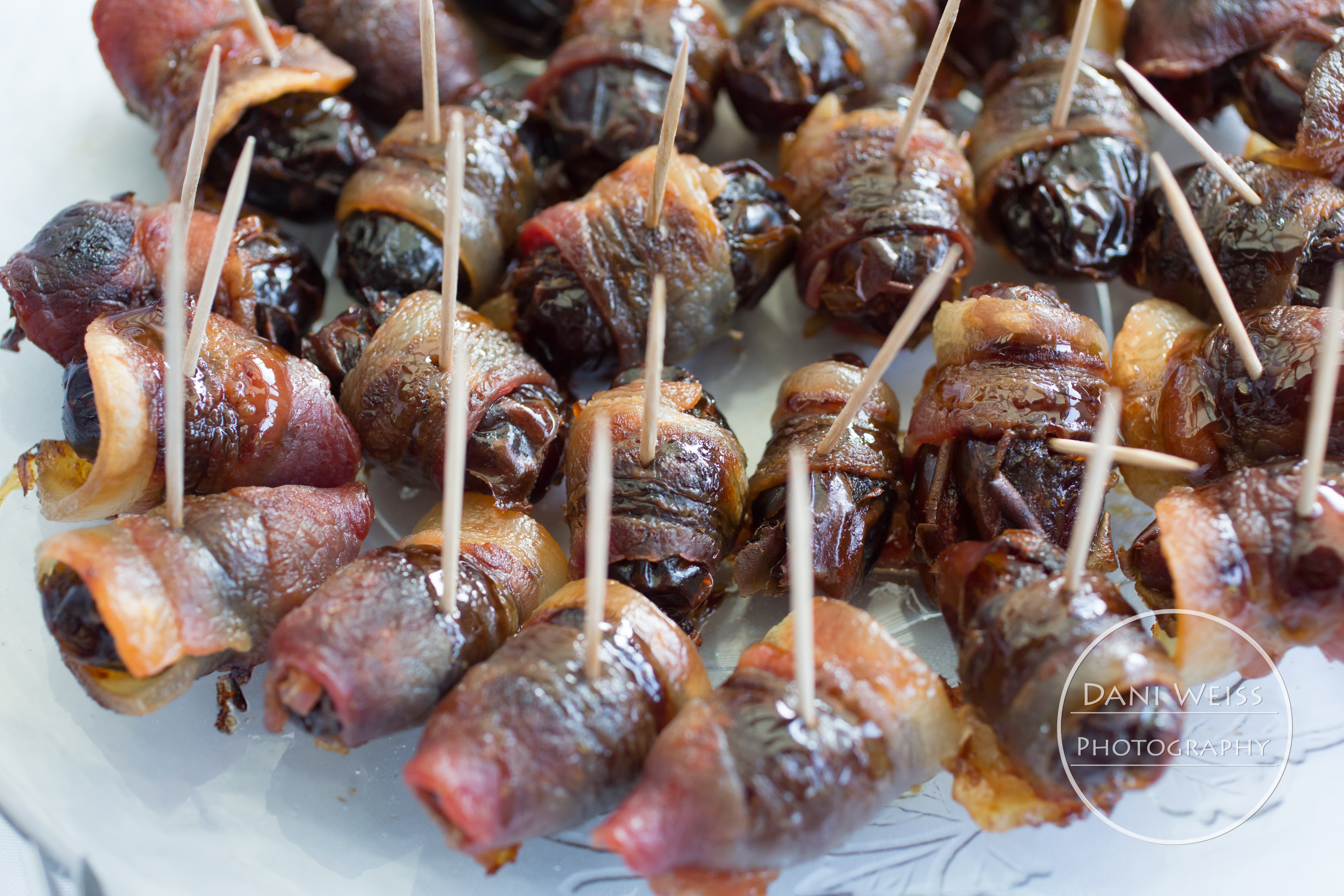 sweet sticky dates stuffed with marcona almonds, wrapped in bacon then baked and drizzled with pomegranate molasses