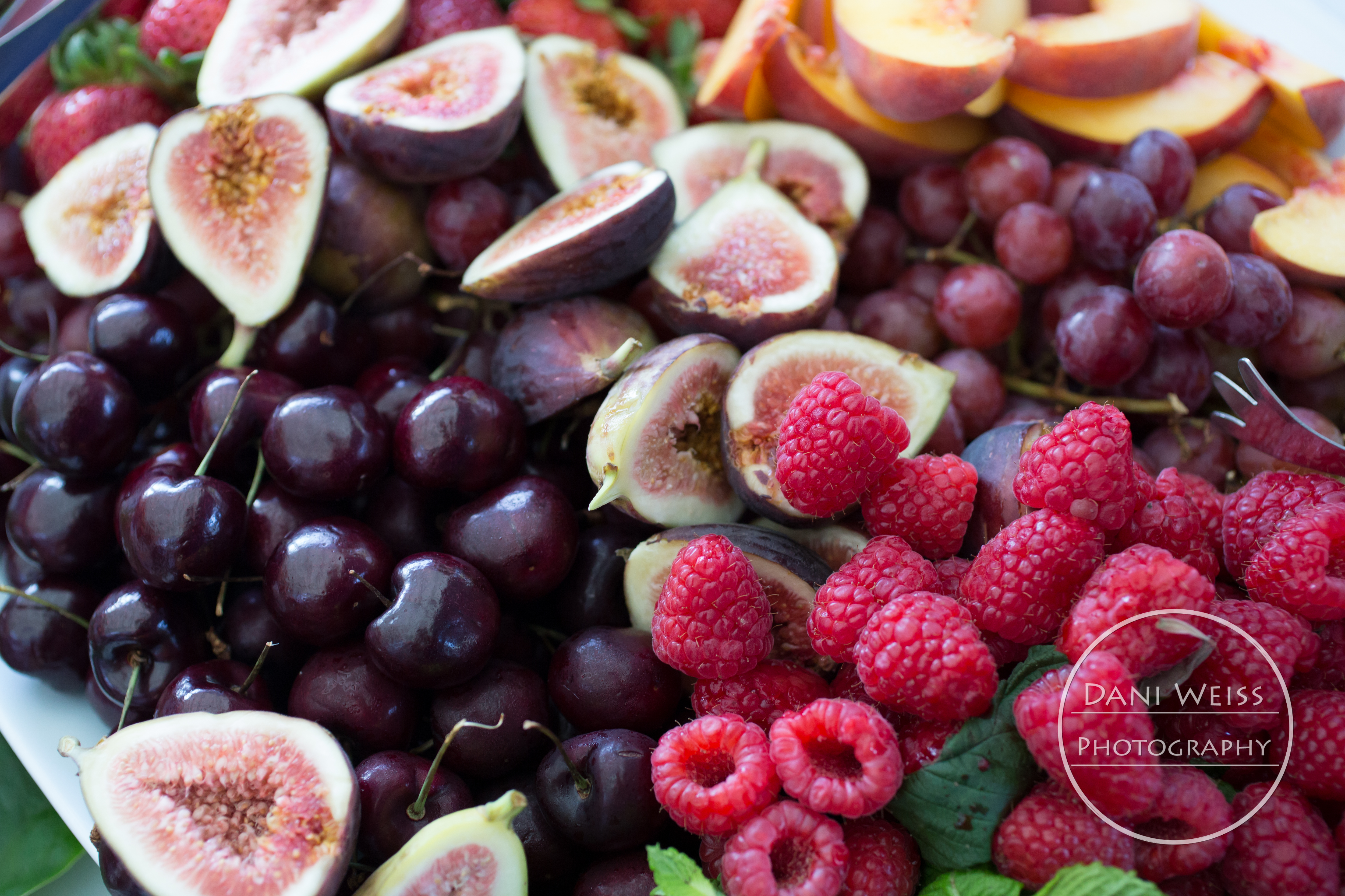 Delish seasonal fruit, fresh figs, raspberries, grapes, cherries, peaches, mint